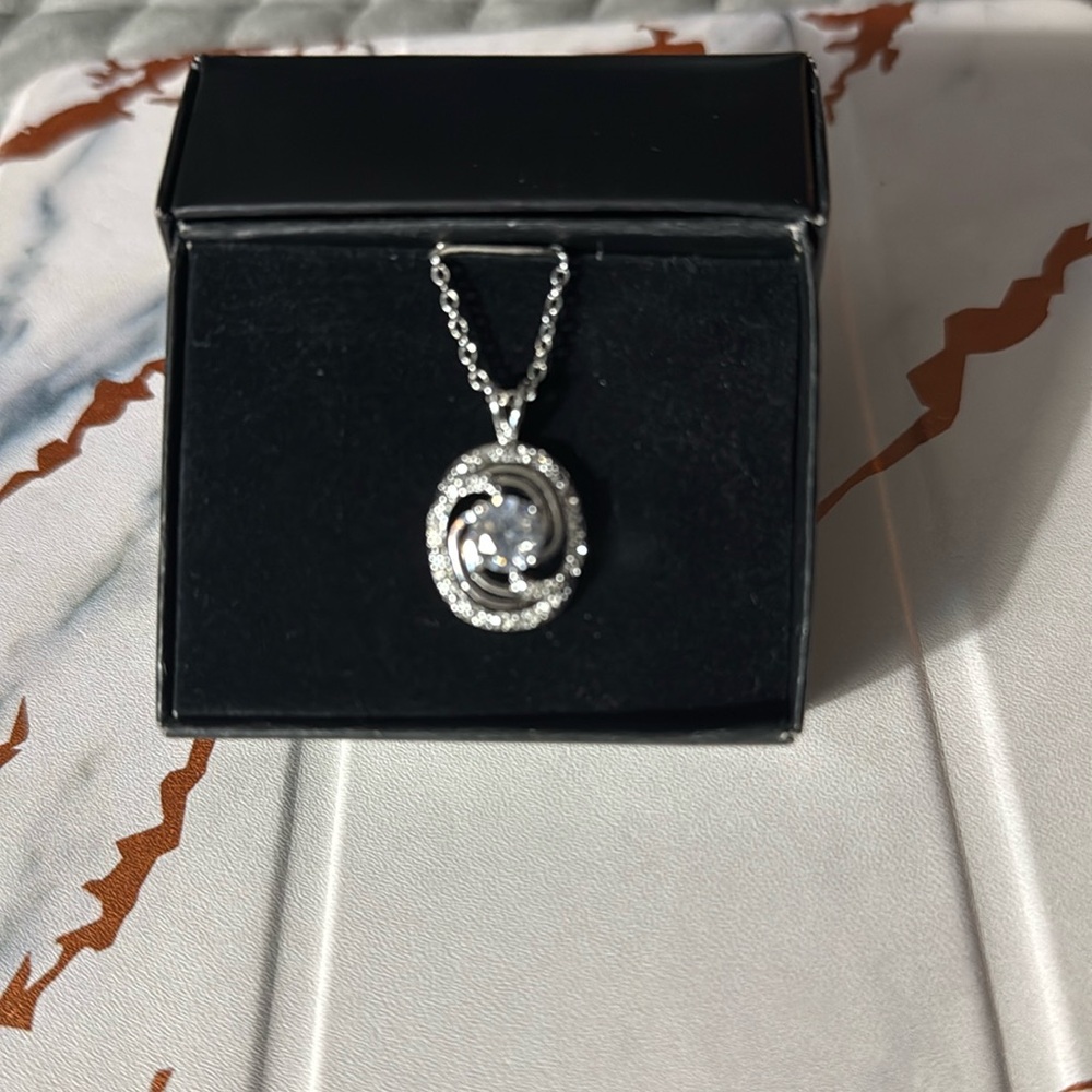 Necklace with sparkling twisted pendant with a cz stone center.